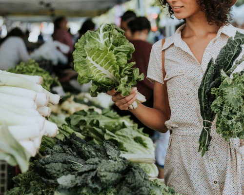 Woman selecting fresh greens at local farmers market