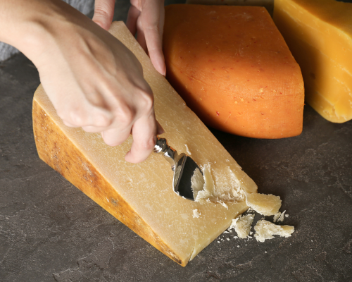 Artisan cheese being cut by hand